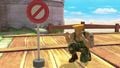Guile crouching next to Isabelle's "do not enter" sign produced by her up smash on Skyloft.