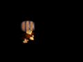 Donkey Kong holds a barrel in the darkness.